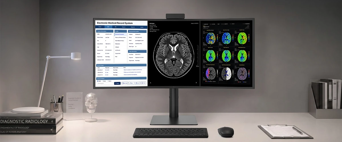 A wide-screen LG 40HT513D-B medical monitor sitting on a desktop displaying patient health records on the left and a series of brain scan images on the right.